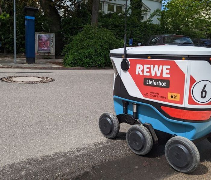REWE setzt in der Last-Mile-Logistik auf ein Lieferbot, das KI-gesteuert die bestellten Produkte direkt an die Haustür der Kunden liefert. (Foto: REWE.)